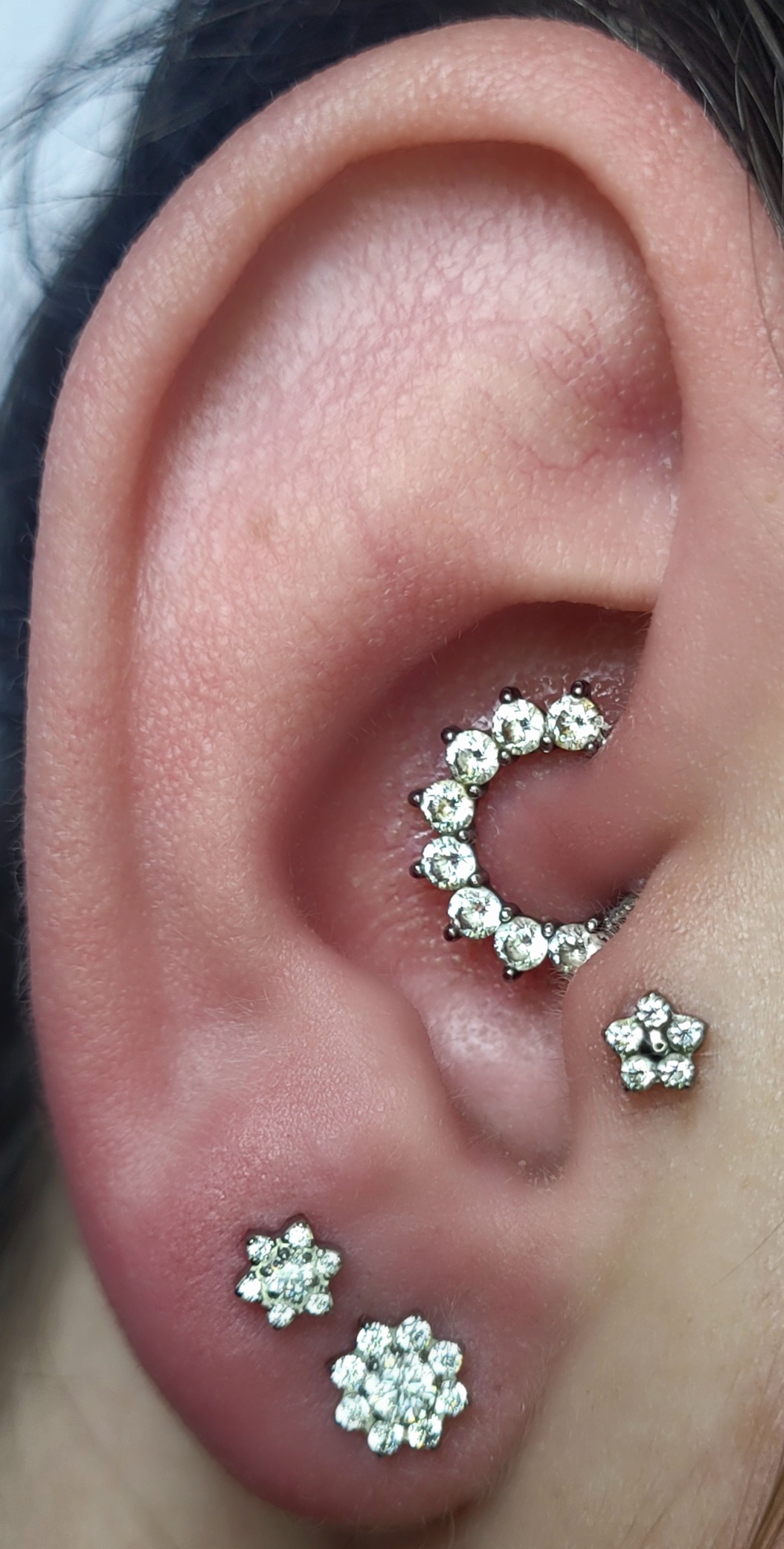 Argola cravejada no daith e studs de flor