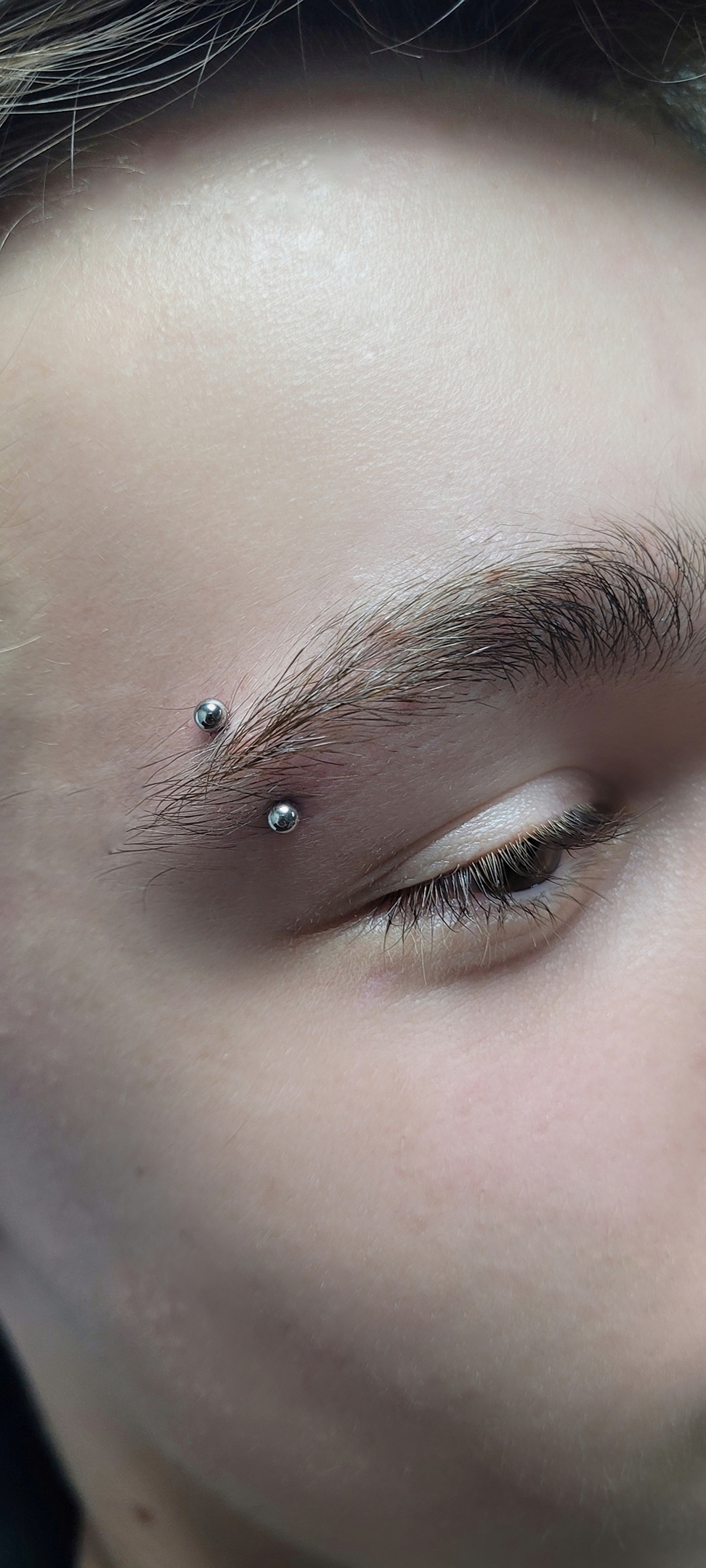 Piercing de sobrancelha com duas perfurações